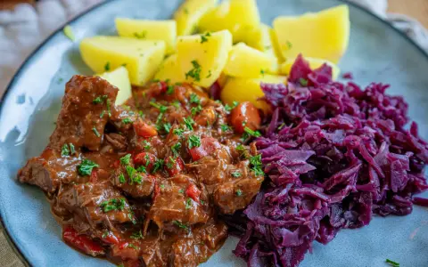 Herzhaftes Gulasch mit Kartoffeln und Rotkohl, ein klassisches Gulasch Rezept, das Leib und Seele wärmt.