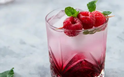 Orzeźwiający drink Wściekły Pies z malinami i miętą, idealny na letnie popołudnie.