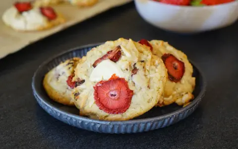 Trois cookies gourmands aux fraises et éclats de chocolat blanc, parfaits pour une pause sucrée.