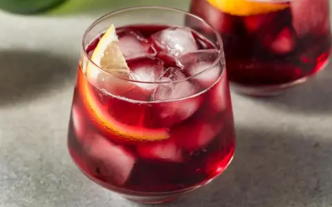 Erfrischender Rotwein im Sommer, serviert mit Eis und Zitronenscheiben. Perfekt für heiße Tage!