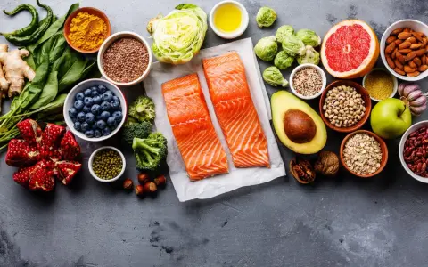 Zdrowe składniki na dietę wątrobową: łosoś, jagody, awokado, orzechy, warzywa i owoce.
