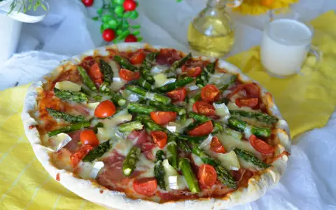 Pyszna pizza ze szparagami, pomidorkami i serem. Idealna na wiosenny obiad.