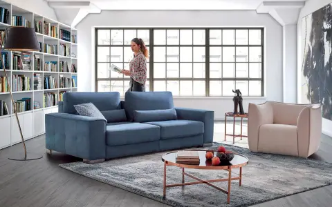 Salon moderne avec canapé bleu, fauteuil beige et bibliothèque. Quelle couleur de canapé choisir pour un style contemporain ?