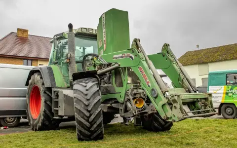 Zielony ciągnik Fendt 714 Vario z ładowaczem czołowym. Dane techniczne tego modelu są imponujące.