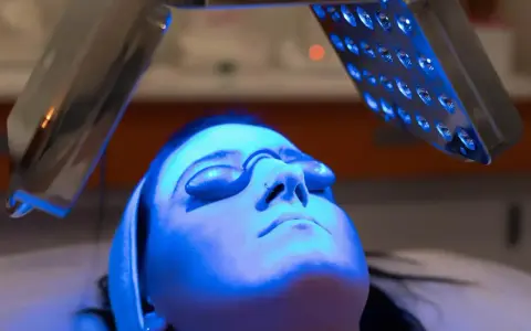 Woman receiving blue light therapy, exploring the blue light benefits for skin.