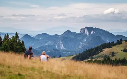 Para odpoczywa po szybkim trekkingu, podziwiając malownicze góry.