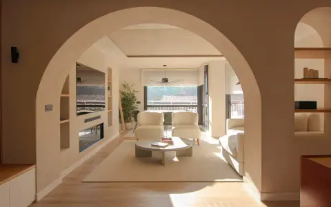 Amplio salón con entrada recibidor integrado. Dos sillones blancos, mesa de centro y sofá invitan a la relajación.