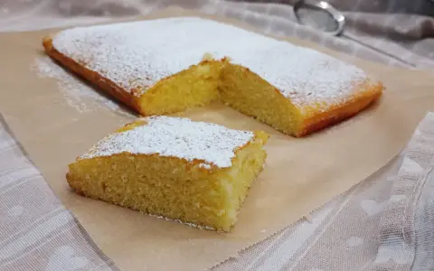 Ein saftiger Kuchen, bestäubt mit Puderzucker, ideal für glutenfreie rezepte mit reismehl.