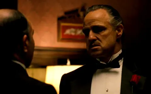 Marlon Brando nei panni di Don Corleone, un'icona de "Il Padrino", in una scena che riassume la sua recensione: potere e dramma.