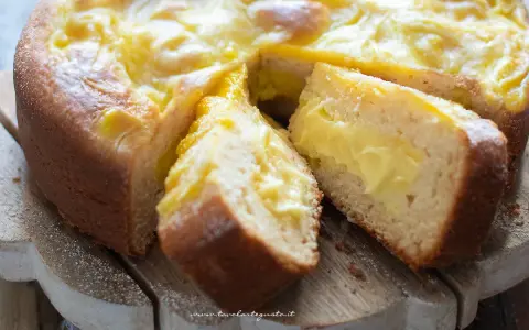 Torta al limone velocissima con crema gialla e soffice impasto, tagliata a fette su un tagliere di legno.
