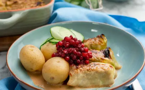 Kåldolmar recept: Varma kåldolmar med kokt potatis, lingon och gurka. En klassisk svensk rätt som passar perfekt till middag.