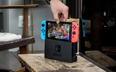 Mano insertando la Nintendo Switch en su base, lista para jugar Mario Kart 8 Deluxe, uno de los mejores juegos estrategia switch.