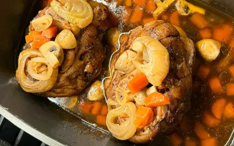 Dwie soczyste golonki, gotowane i pieczone, w aromatycznym sosie z marchewką, cebulą i grzybami. Najlepsza golonka gotowana i pieczona.