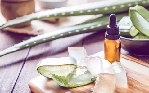 Aloe Vera Gel und Öl auf Holzbrett. Viele fragen sich, ob Aloe Vera gegen Pickel hilft. Hier sind die Zutaten für eine natürliche Hautpflege.