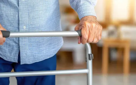 Dłoń seniora na chodziku. Poradnik: jak wybrać chodzik dla seniora, by zapewnić mu bezpieczeństwo i komfort.