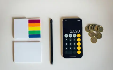 Kalkulator na telefonie pokazuje 2020, obok leżą monety euro. To może być początek oszczędzania na depozyt prosumencki.