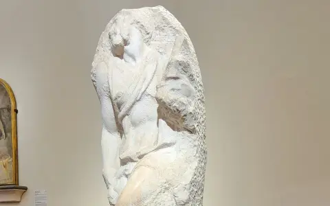 Niedokończony posąg Michała Anioła, ukazujący fragment ludzkiego ciała wyrzeźbionego z marmuru.