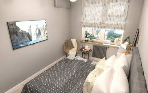 Acogedora habitación pequeña con cama, TV en la pared y ventana con vistas a la ciudad.