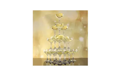 Jak przygotować "champagne tower" żeby była bezpieczna i efektowna? Piramida z kieliszków szampana, wypełniona złotym trunkiem, na tle błyszczącej, złotej scenografii.