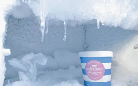 Eisige Eiszapfen hängen über einem Eiscremebecher. Das zeigt, was bedeutet no frost: keine Eisbildung, nur gefrorene Köstlichkeiten.