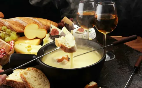 Un délice fumant de fondue au fromage, pain croustillant et vin blanc. Un aperçu des spécialités Auvergne Rhône Alpes.