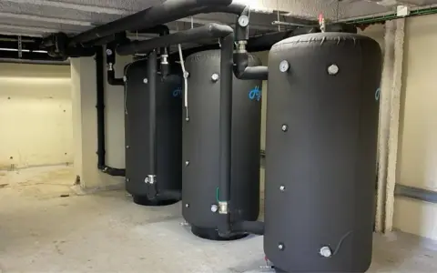 Tres grandes calderas para hoteles, con aislamiento negro y tuberías conectadas, listas para proveer agua caliente.