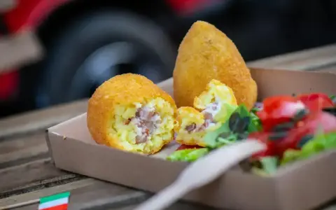 Arancini co to? Pyszne, złociste kulki ryżowe z nadzieniem, podane z sałatką. Idealna włoska przekąska.