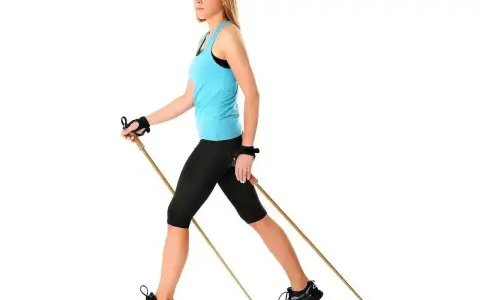 Kobieta w sportowym stroju ćwiczy nordic walking, używając kijków. Dobór odpowiednich kijków do nordic walking to klucz do efektywnego treningu.