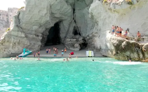 Bambini e adulti si divertono nella grotta del Palombaro, tra scogli e acque cristalline.
