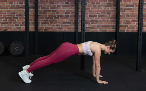 Frau in Liegestützposition, um den Rumpf zu stabilisieren.