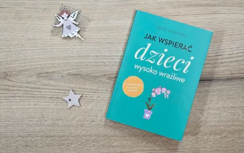 Książka "Jak wspierać dzieci wysoko wrażliwe" obok aniołka i gwiazdki.