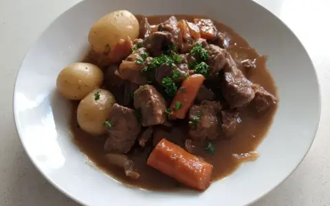 En härlig fransyska gryta med mört kött, mjuka potatisar och saftiga morötter, toppad med färsk persilja.