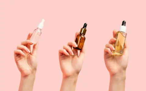 Trzy dłonie trzymają buteleczki z serum. Zastanawiasz się, jakie serum do twarzy po 40. wybrać?