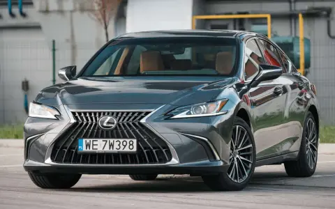 Elegancki, ciemnoszary Lexus 300h z brązowym wnętrzem stoi na parkingu.