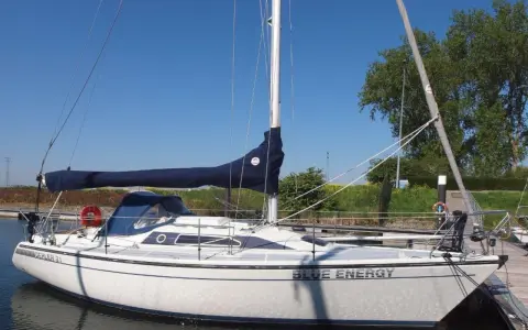 Weiße Segelyacht "Blue Energy" mit blauem Segel, liegend am Steg. Interessante dehler 31 technische daten für Segelfreunde.