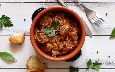 Aromatyczny bigos w glinianym naczyniu, z dodatkiem ziół i pieprzu. Idealne jakie przyprawy do bigosu.