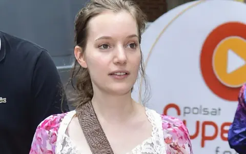 Zuzanna Jurczak, The Voice of Poland, w kwiecistej sukience z koronką, z brązowym paskiem przez ramię.