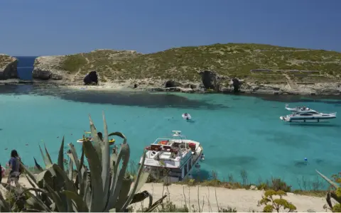 Malta wakacje: turkusowa woda, skaliste wybrzeże z jaskiniami i łodzie. Idealne miejsce na relaks.