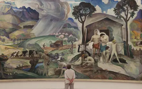A mural depicting rural life and labor, reminiscent of the Wyeth family artists' style, with figures tending to livestock and fields under a dramatic sky.