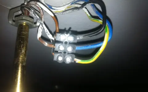 Widok z bliska na połączenie przewodów elektrycznych żyrandola z kostką.