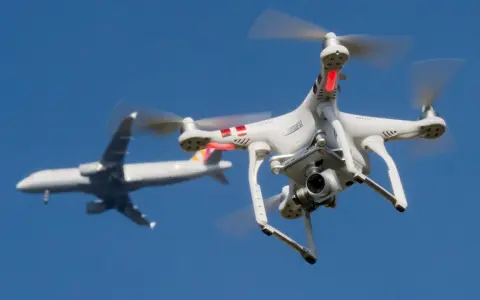 Eine Drohne fliegt in Deutschland nah an einem Flugzeug vorbei.
