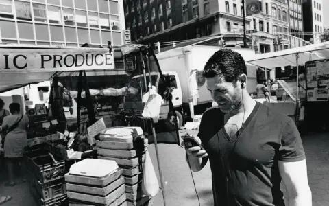 Uomo con auricolari al mercato, un'istantanea di Lee Friedlander.