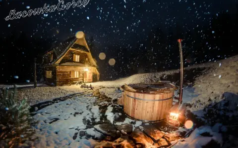 Nocą w bacówce u Winiarskich, przytulny drewniany domek i gorąca balia w śnieżnej scenerii.