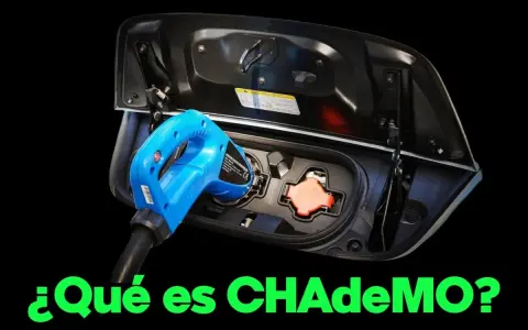 Un conector CHAdeMO azul se inserta en el puerto de carga de un coche eléctrico.