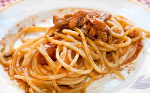 Spaghetti alla chitarra con sugo di carne, un piatto ricco e saporito, pronto per essere gustato.
