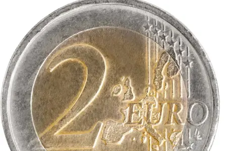 Gros plan d'une pièce de 2 euros commémorative. Le chiffre "2" est bien visible, ainsi que le mot "EURO" et une carte de l'Europe.