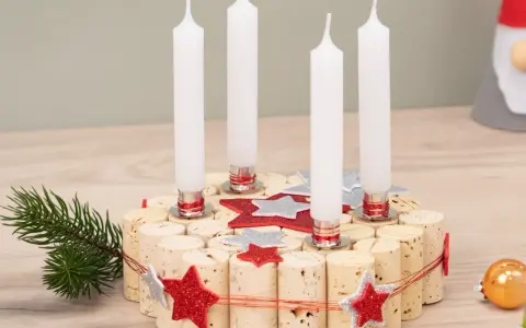 Selbstgemachter Adventskranz aus Korken mit vier Kerzen, Tannenzweig und Glitzersternen. Perfekt zum Adventskranz basteln mit Kindern.