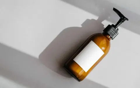 Flacone ambrato con etichetta bianca vuota e dispenser nero. Attenzione agli ingredienti come il cetearyl alcohol fa male.
