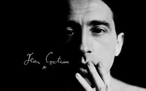 Primo piano di un volto illuminato da un lato, con la firma "Jean Cocteau" in corsivo. Un'immagine evocativa dei suoi film.