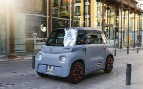 Citroën Ami gris en movimiento por la ciudad. Descubre el carnet AM precio y disfruta de la movilidad urbana.
